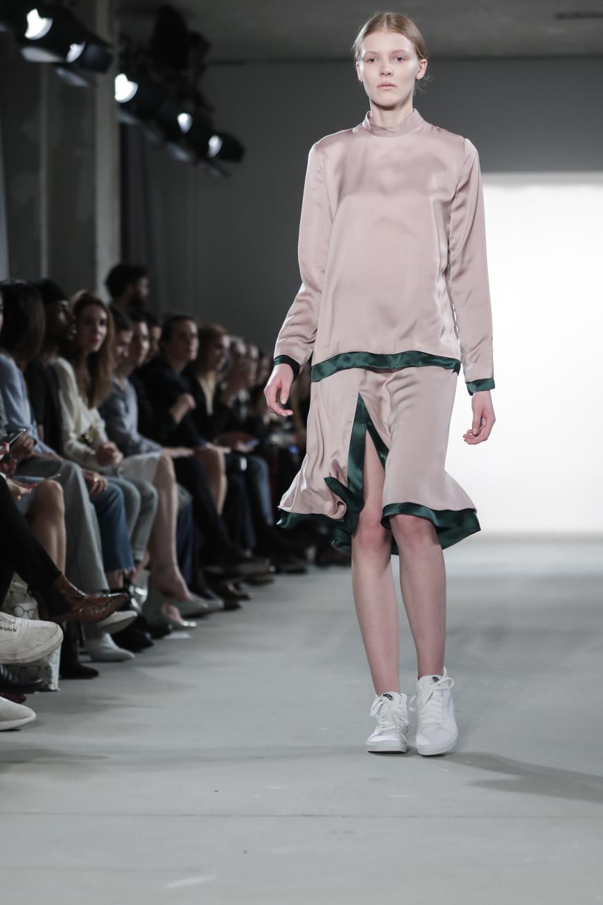 Der in Laos geborene Designer Hien Le setzte in Berlin auf sportlich-schlichte Eleganz und Stilbrüche. Bei diesem Look überzeugen uns vor allem die Kombination von Rosé und dunkelgrün, sowie die Sneaker zum Satinkleid. Ein super Büro-Outfit!
