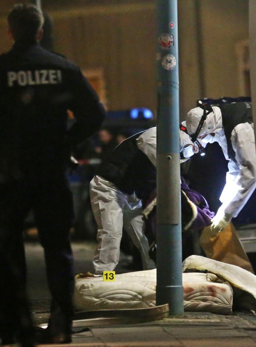 Polizisten der Spurensicherung untersuchen am Freitag in Herne (Nordrhein-Westfalen) vor dem Haus, in dem es einen Wohnungsbrand gegeben hatte, eine Matratze. In der Wohnung wurde ein Toter gefunden.