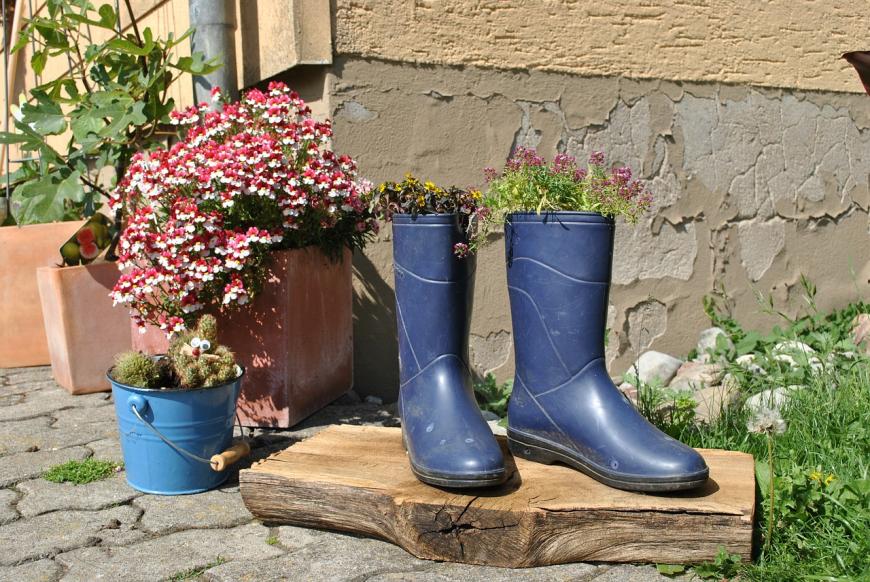 Fast schon Upcycling-Klassiker: Zum Pflanzbehältnis umfunktionierte alte Haushaltseimer und Gummistiefel.