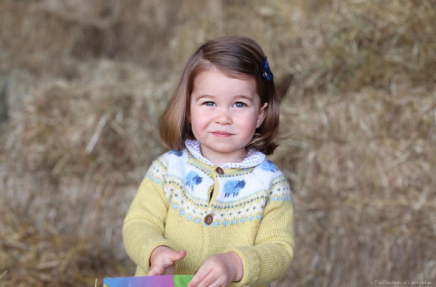 Im gelben Strickjäckchen schaut die kleine Charlotte etwas skeptisch in die Kamera.