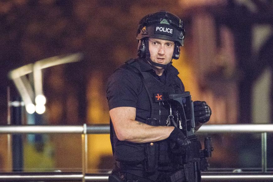 Ein schwer bewaffneter Polizist am Tatort in Manchester