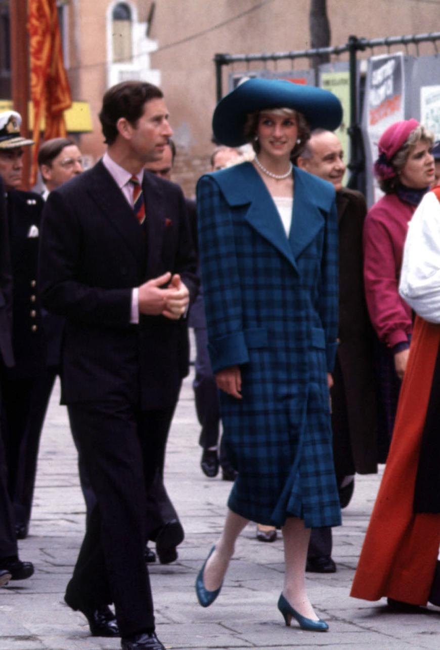 Ein großer Hut und ein Trenchcoat, Lady Di 1985 mit ihrem Mann Prinz Charles.