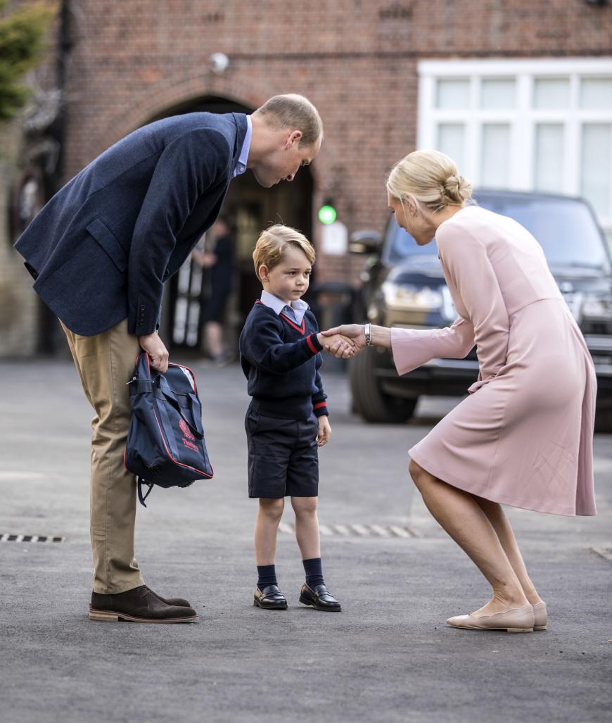 Noch etwas schüchtern schüttelt Prinz George die Hand der Schuldirektorin Helen Haslem, die den royalen ABC-Schützen heute in Empfang nahm.