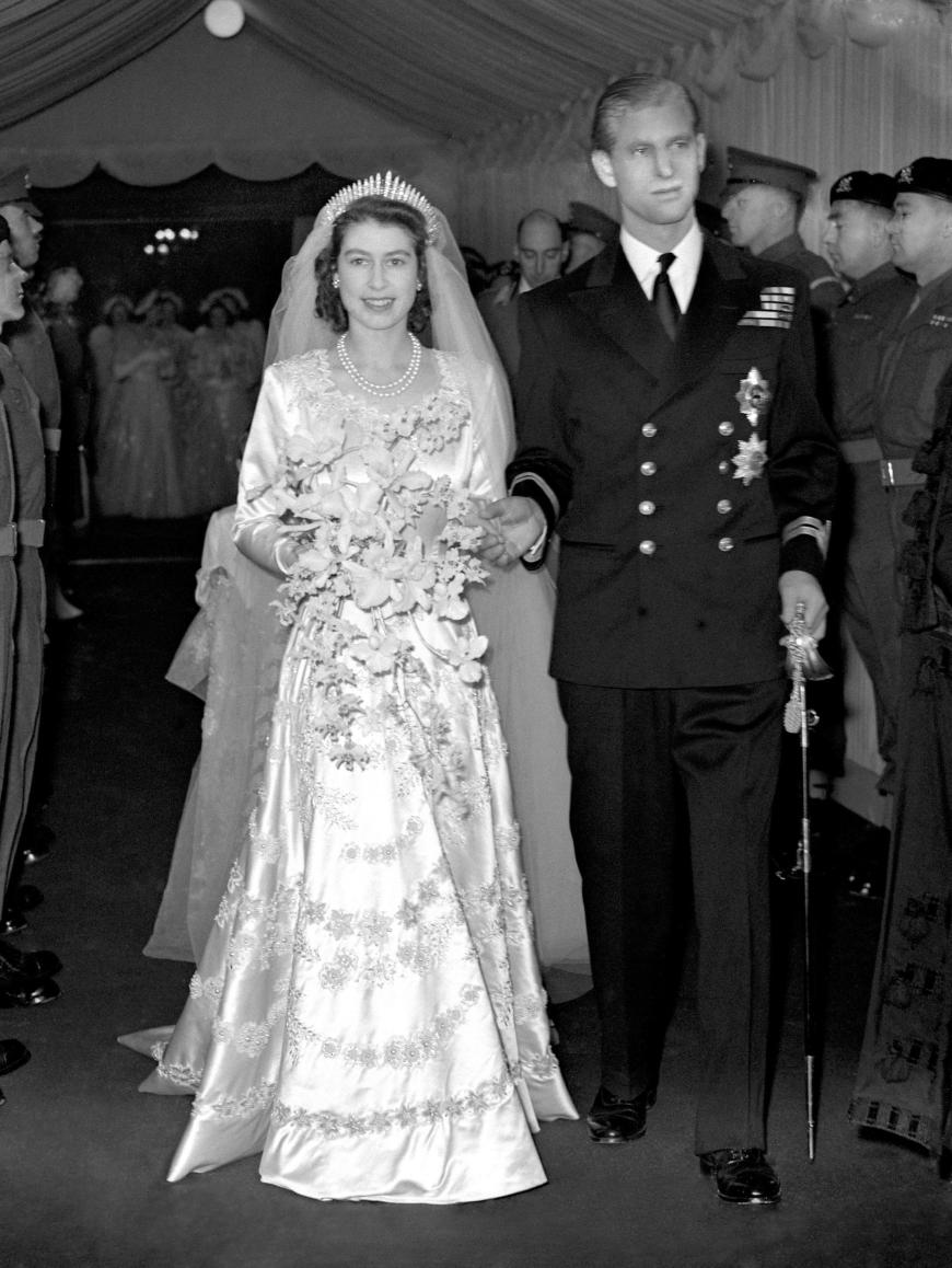 Na, wer erkennt dieses hübsche Paar? Es sind Queen Elisabeth II. und Prinz Philip, die im Juli 1947 ihre Verlobung bekannt gaben. Im November folgte dann die große Hochzeit im Buckingham Palace. Die Braut trug bei ihrer Trauung zwei Perlenketten. Ihr berühmt-berüchtigtes Hochzeitskleid war das Resultat von vielen Stunden Arbeit. 350 Frauen benötigten sieben Wochen, um den Entwurf zu verwirklichen, der von dem Couturier Norman Dartnell designt und nur drei Monate vor der Zeremonie genehmigt wurde.