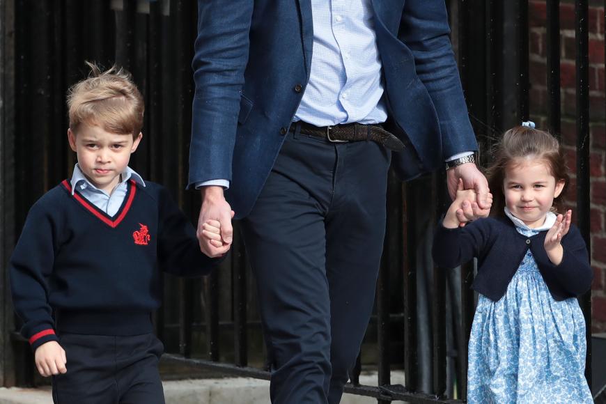 Medien-Profi: Prinzessin Charlotte winkt in einem blau-weißen Kleid keck den anwesenden Fotografen, Bruder George trägt seine Schuluniform.