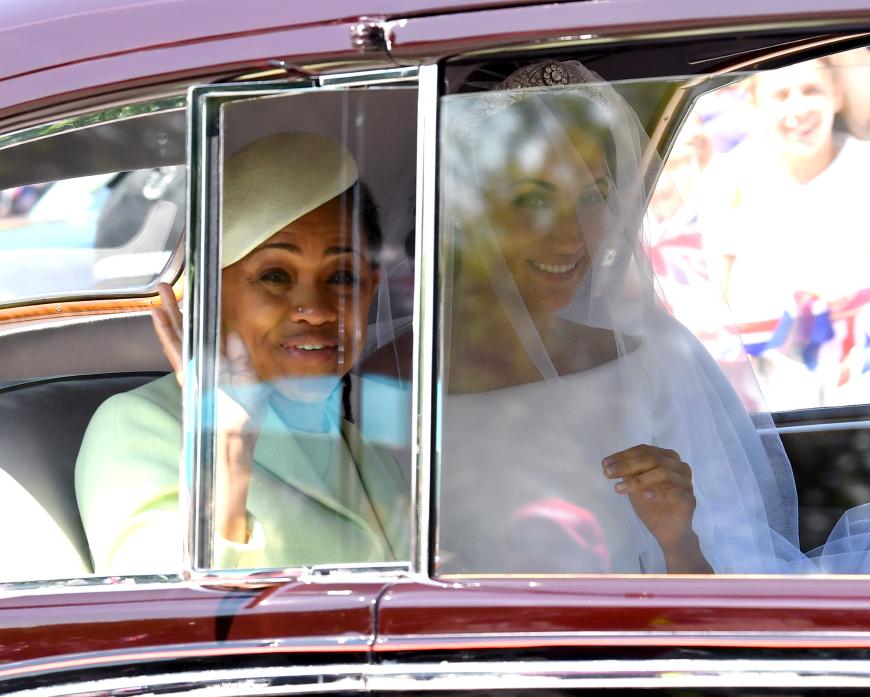 Der erste Blick auf die Braut: Meghan Markle rollt an! Gemeinsam mit Mutter Doria Ragland wird die Braut zur royalen Hochzeit chauffiert. Mama Doria trägt ein Kleid mit Mantel von Fernando Garcia und Laura Kim für Oscar de la Renta.