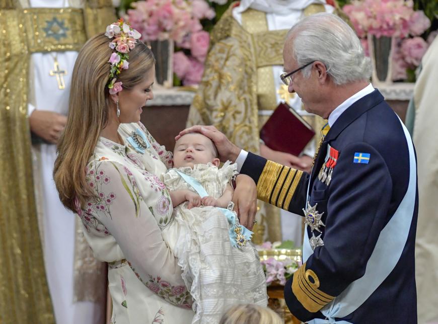 König Carl Gustaf streichelt seine jüngste Enkeltochter, die inzwischen eingeschlummert ist.
