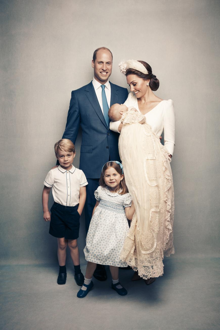 Herzogin Kate schaut entzückt auf Prinz Louis herunter. Prinz William strahlt bis über beide Ohren in die Kamera und Prinz George posiert hier mit ernster Mine, während Prinzessin Charlotte mit einem verschmitzten Lächeln alle Blicke auf sich zieht.