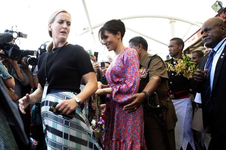 Herzogin Meghan lächelt gequält, als das Sicherheitspersonal sie aus dem Menschengedränge in Suva, Fidschi befreien muss.