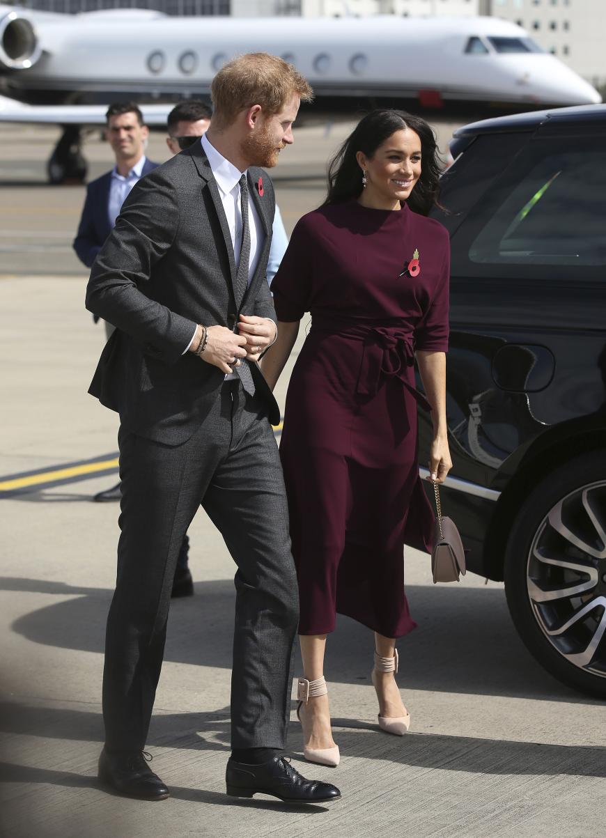 Bei der Weiterreise von Australien nach Neuseeland trug Herzogin Meghan ein weinrotes Kleid von Hugo Boss. Sie reiste in den Aquazurra-Pumps, die sie auch bei der Abschlussfeier der Invictus Games in Sydney anhatte. Ihre Tasche stammt vom Label Cuyana.