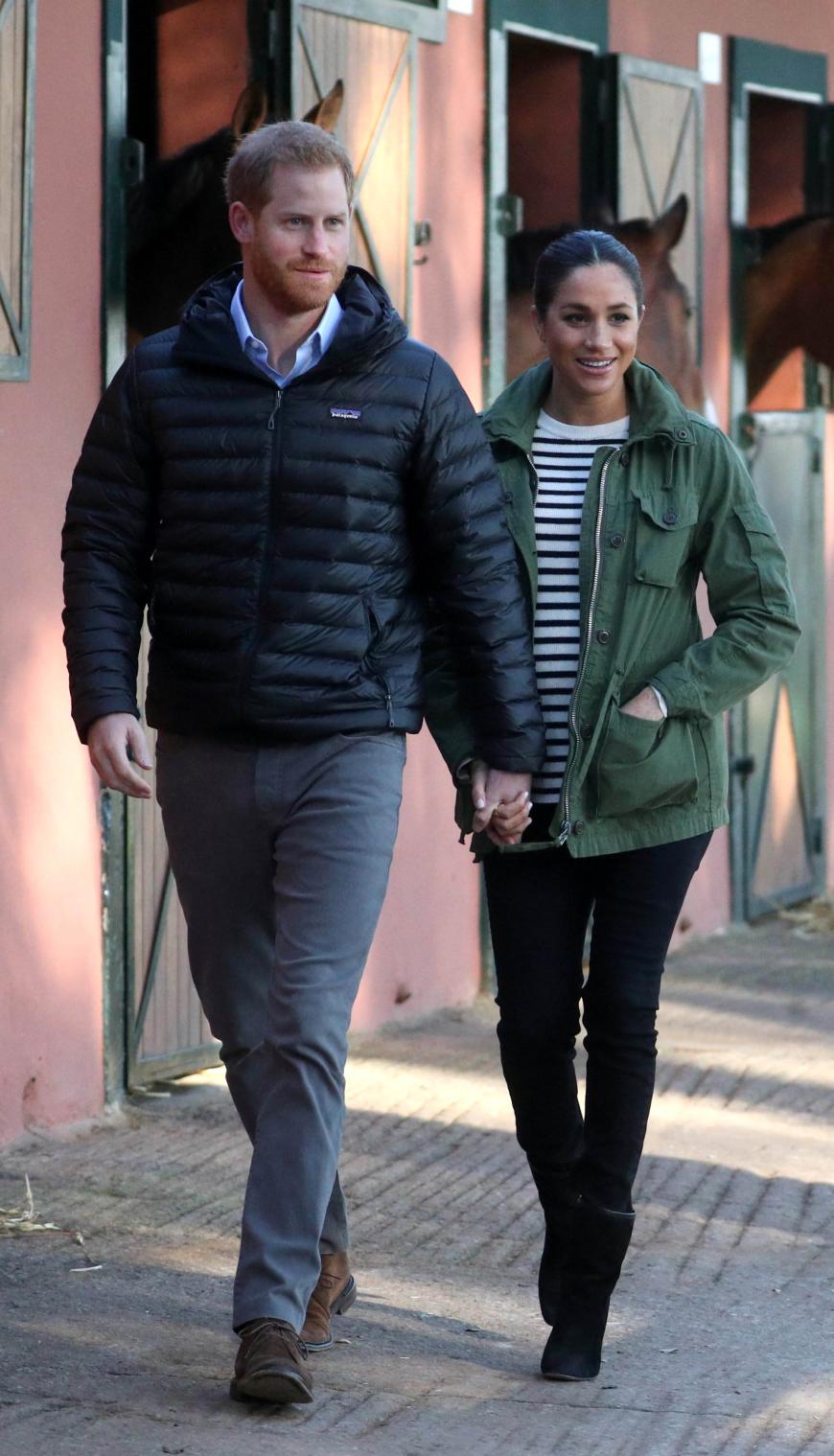 Zu Besuch in Marokko: Drei Termine - drei Looks! Prinz Harry und Meghan starteten den Tag auf einem Pferdehof, auf dem behinderten und benachteiligten Kindern durch den Umgang mit Pferden geholfen wird. Meghan trug eine schwarze Jeans, einen schwarz-weiße-gestreiften Pullover und einen khakifarbenen Parka. Hand in Hand sahen sich die werdenden Eltern die Pferde an.