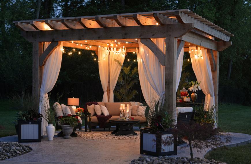 Mit den richtigen Gartenmöbeln und einer hübschen Beleuchtung wird die Atmosphäre idylisch.