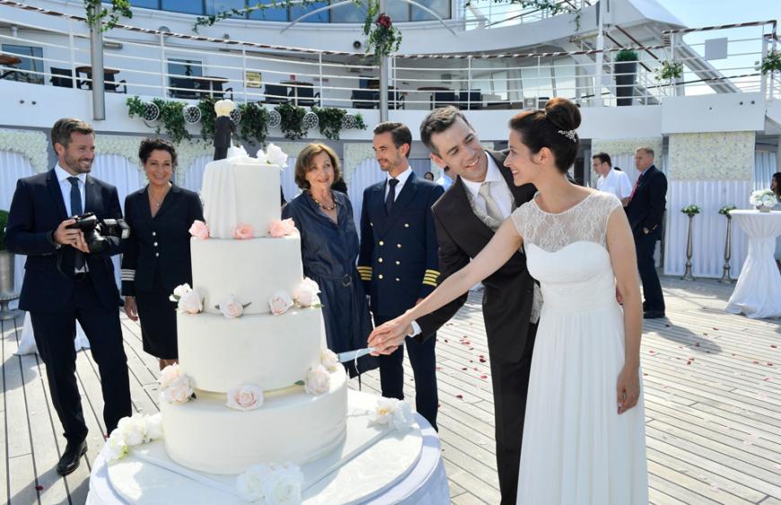 Eheglück auf hoher See: Konrad (Andreas Thiele, 2. v. r.) und Anke Breuer (Katrin Anne Heß, r.) feiern ihre Hochzeit in Anwesenheit von Hochzeitsplaner Tom (Jan Hartmann, l.), Hanna Liebhold (Barbara Wussow, 2. v. l.), Kerstin Cramer (Gila von Weitershausen, 3. v. l.) und Kapitän Max Parger (Florian Silbereisen, 3. v. r.) in der