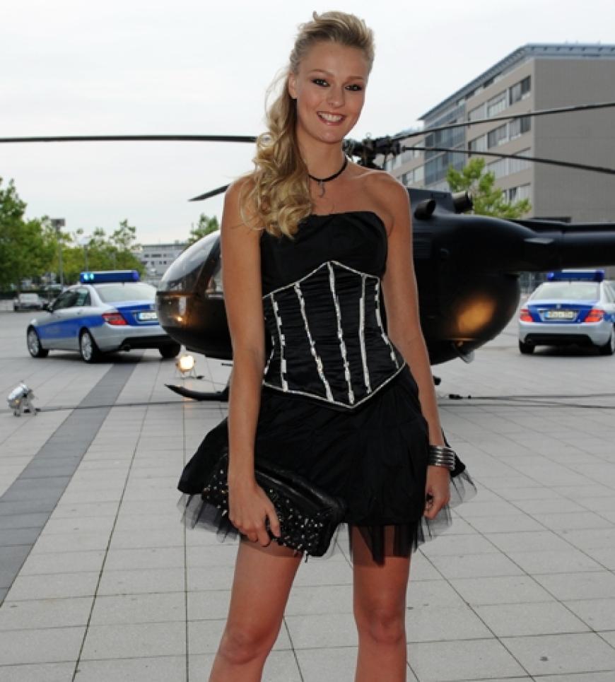 Model Miriam Höller posiert im zarten Sommerkleidchen vor einem Hubschrauber