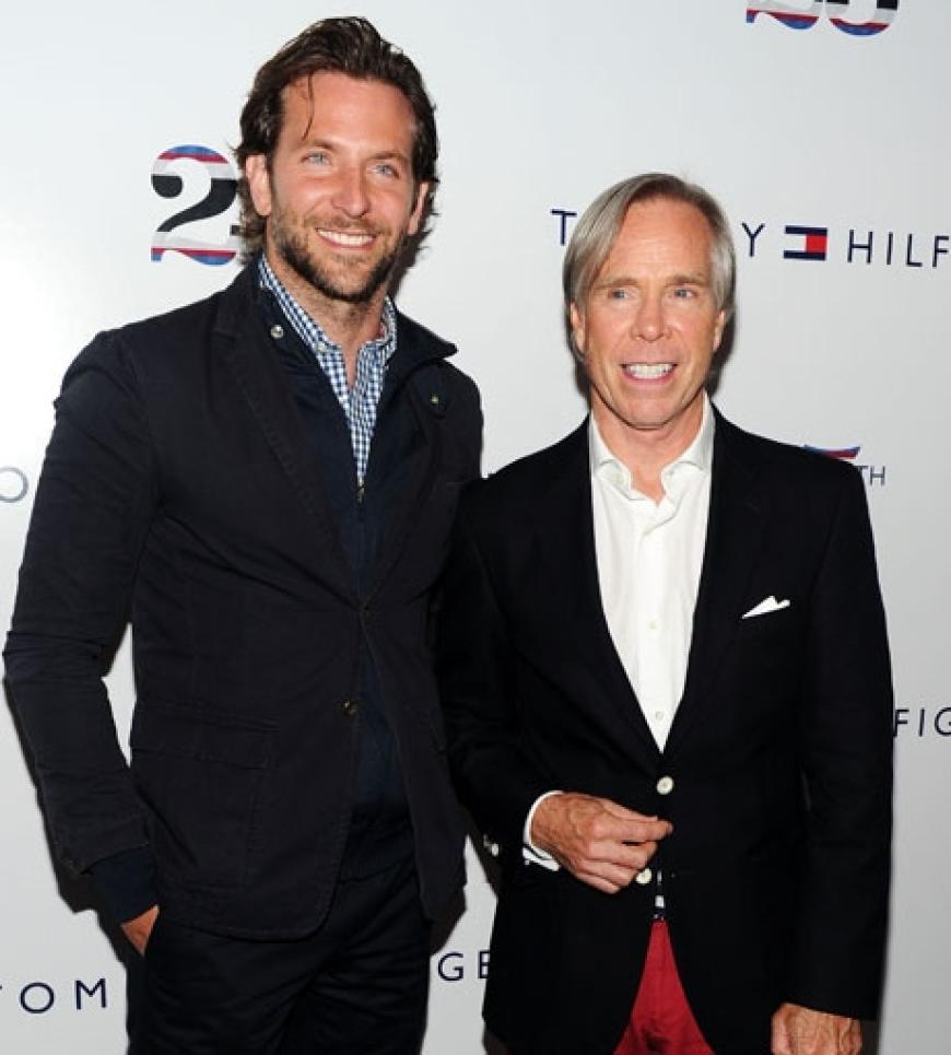 Schauspieler Bradley Cooper stellt sich mit dem Modeschöpfer für ein Foto auf