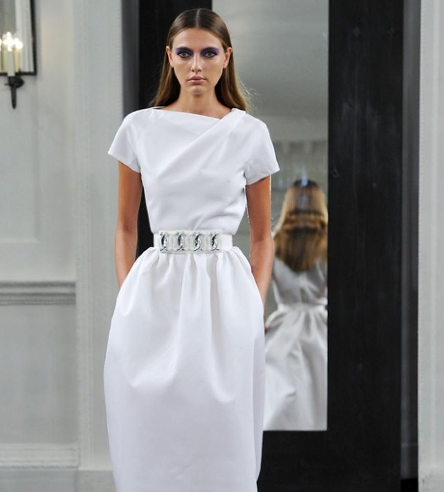 Das lange weiße Abendkleid mit Silbergürtel wirkt an dem dünnen Model viel zu voluminös