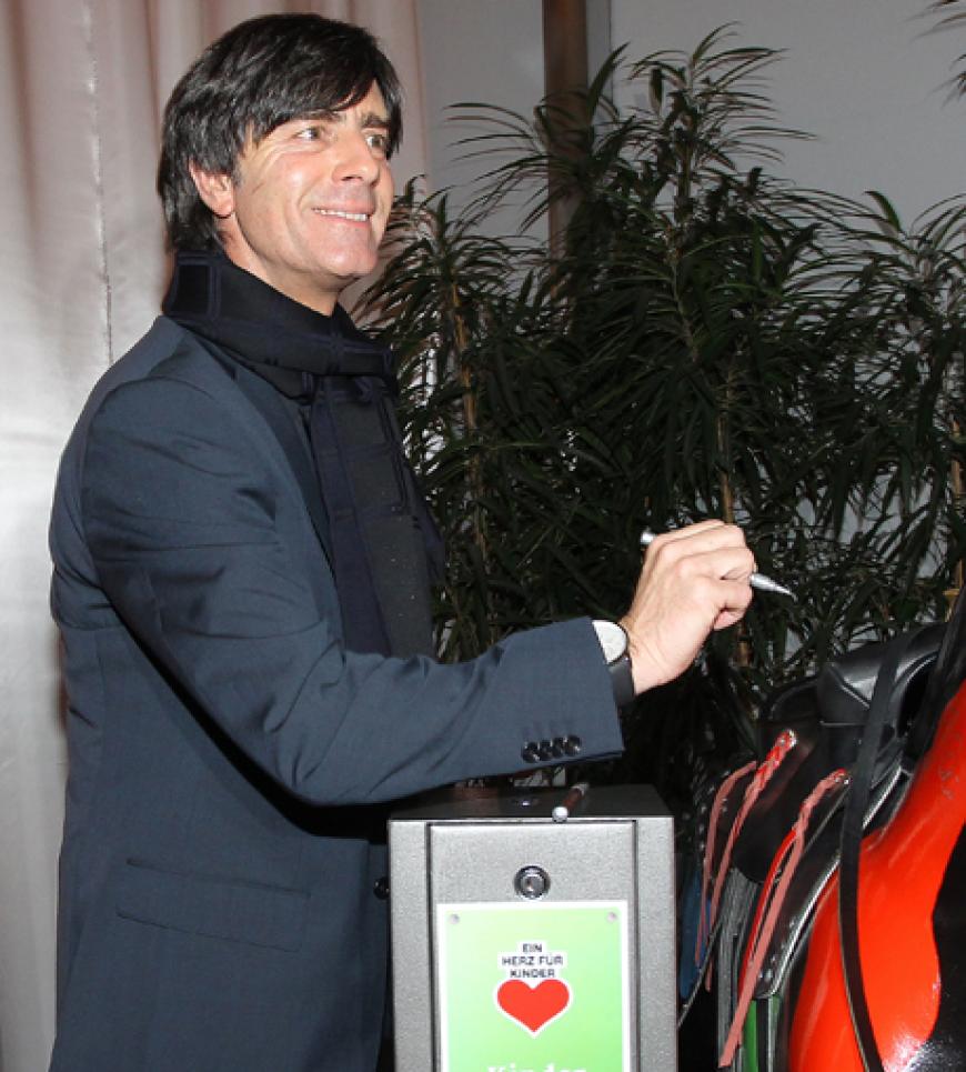 Jogi Löw ließ die Spendenkasse klingeln: sein berühmter blauer Kaschmir-Pullover wurde für über eine Million Euro an Kaufhof-Chef Lovro Mandac versteigert