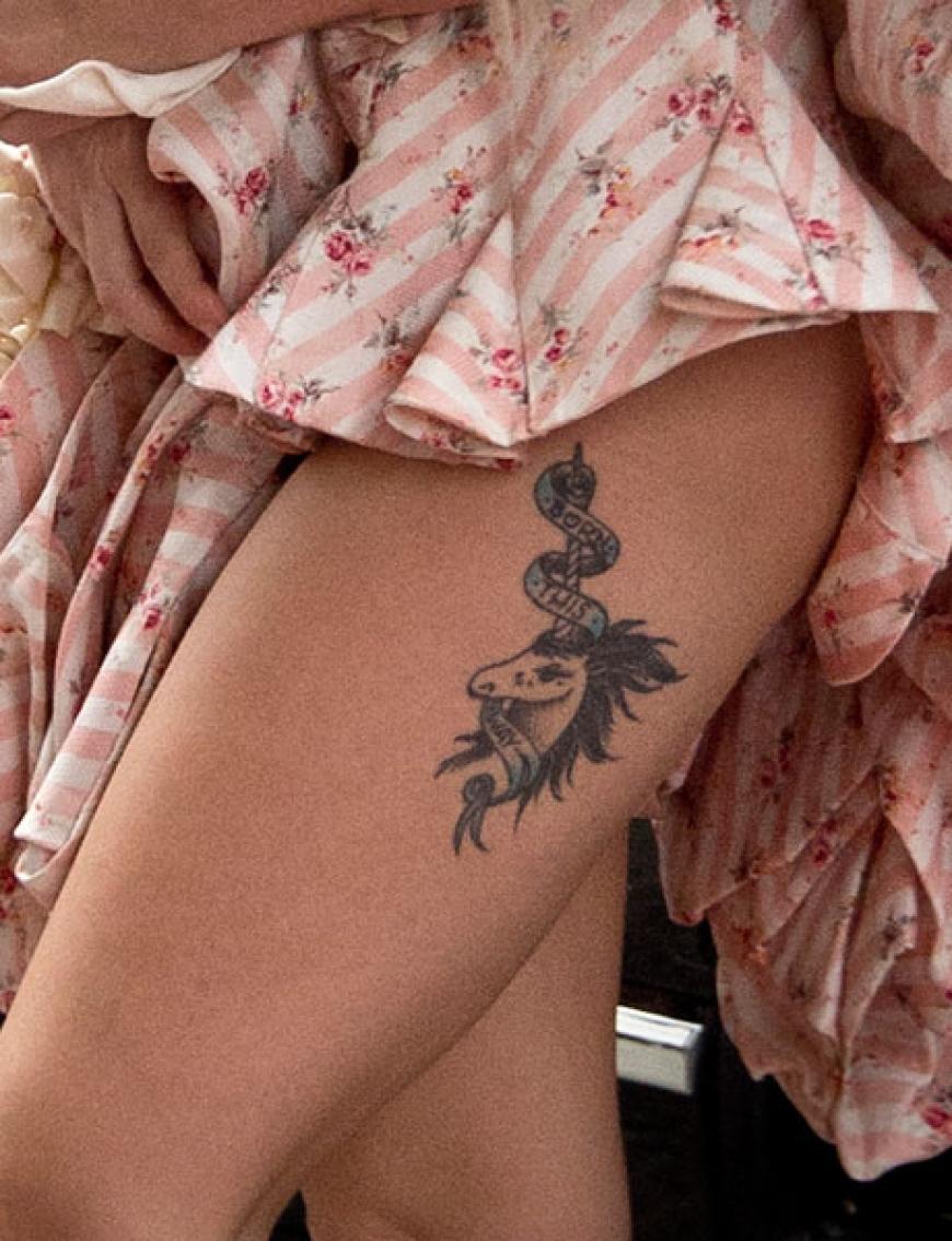 Und präsentiert stolz ihr Oberschenkel-Tattoo - ein Einhorn mit dem Schriftzug