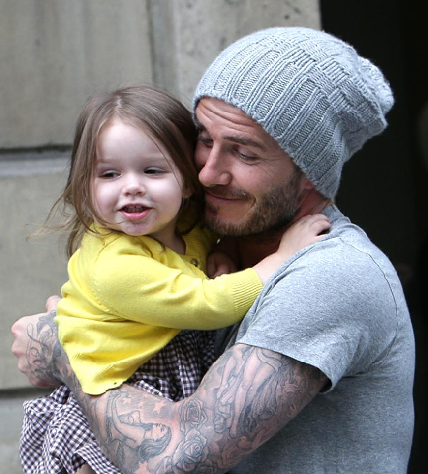 Die kleine Harper hat die Haare schön und klammert sich bei einem Spaziergang durch Paris wie ein süßer Koalabär an Papa Becks