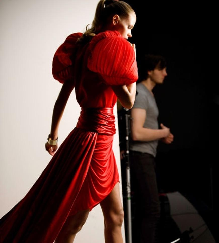Julia Stegner lächelt in einem roten Seidenkleid von Anne Valérie Hash.