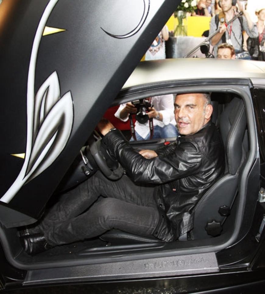 Audigier sitzt in einem Lamborghini, der auf dem Stand seines Labels