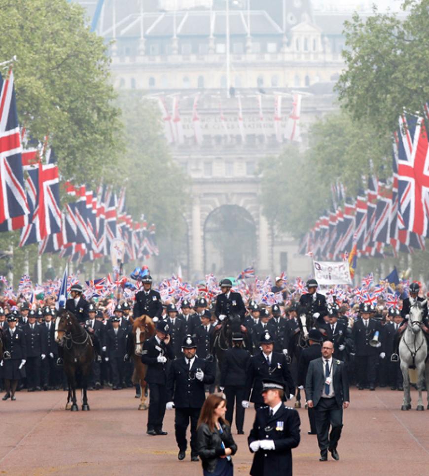 Die Sicherheitsleute führen die Menschen zum Buckingham Palace, sodass sie einen guten Blick auf das Prinzenpaar hat
