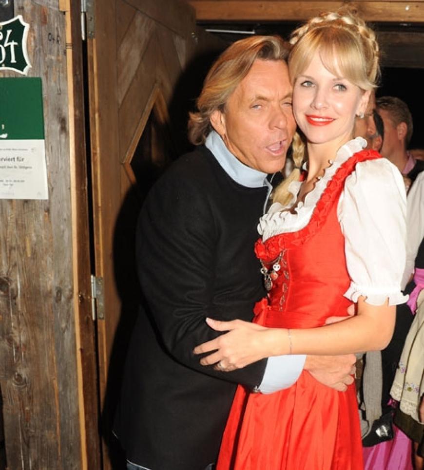 Modedesigner Otto Kern und seine Frau Naomi Valeska in einem roten Dirndl