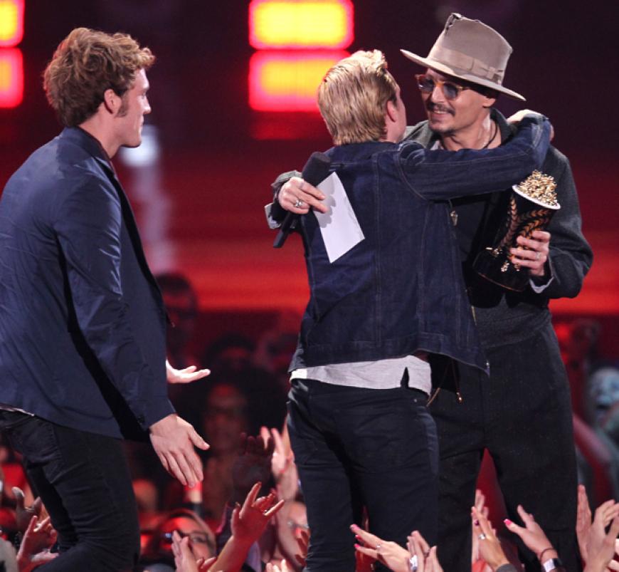 Johnny Depp (r.) überreicht Sam Claflin (l.) und Josh Hutcherson den Preis für den