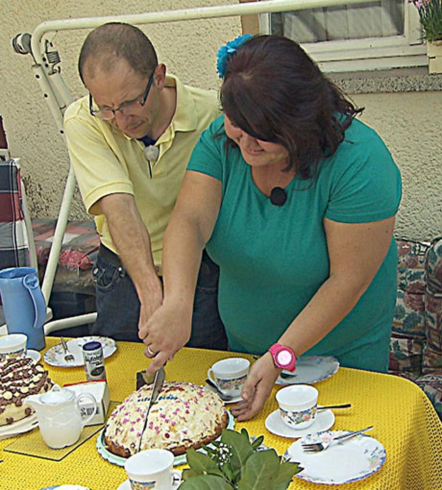 Steffen und Nicole schneiden die 'Verkuppeltorte' an, die Steffens Mutter zur Begrüßung von Nicole gebacken hat