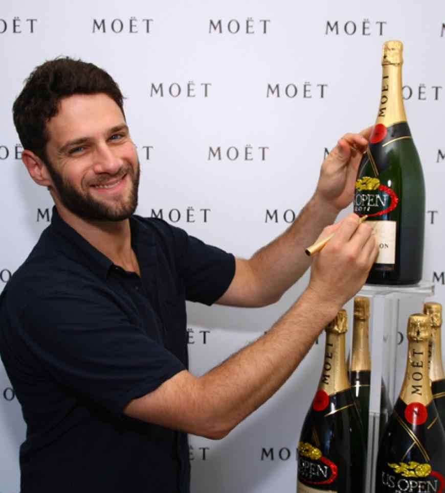 Schauspieler Justin Bartha signiert eine Flasche