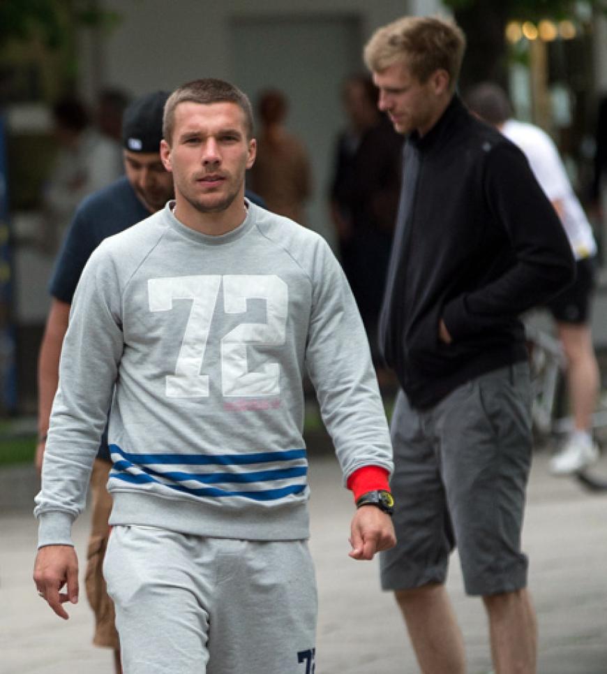 Im Leger-Look: Lukas Podolski und Per Mertesacker (im Hintergrund) auf Bummeltour durch das polnische Sopot
