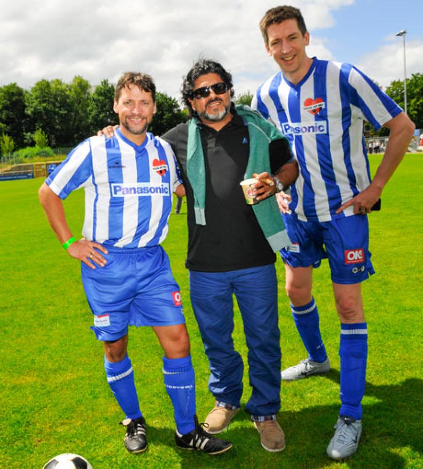 Schauspieler Patrick Bach (l.) und Moderator Steffen Hallaschka (r.) posieren mit dem Schiedsrichter, einem Diego-Maradona-Double