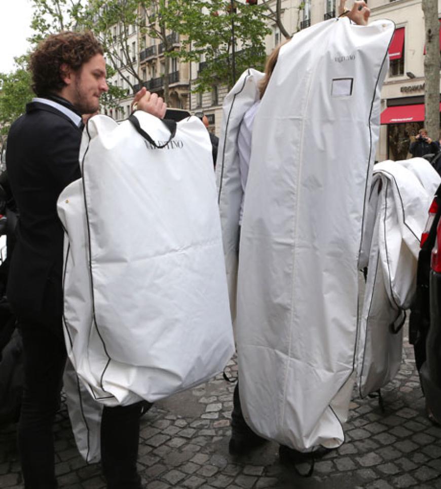 XXL-Shopping bei Valentino. Angestellte müssen die Kleidersäcke ins Auto tragen. Ob sich in einem wohl Kims Hochzeitskleid befindet?
