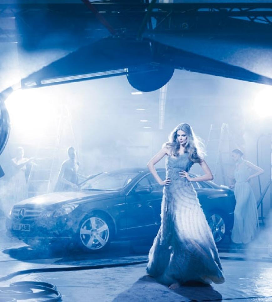 Das Werk von Lindbergh greift die Szenerie eines klassischen Mode-Shootings auf. Im Rampenlicht stehen Julia Stegner und das E-Klasse Coupé. Sie werden bewundert von fünf Frauen, die in die Rollen von Assistentinnen am Set schlüpfen