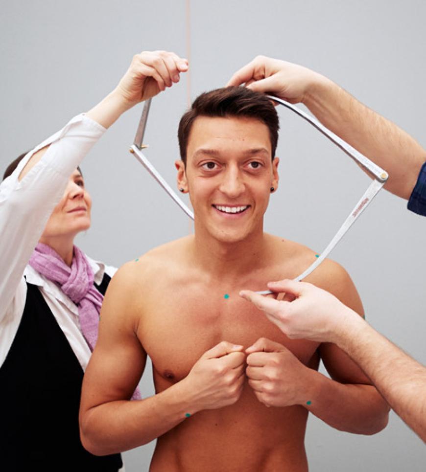 Der deutsche Fußballnationalspieler Mesut Özil wird von einem Mitarbeiter von Madame Tussauds Wachsfigurenkabinett vermessen