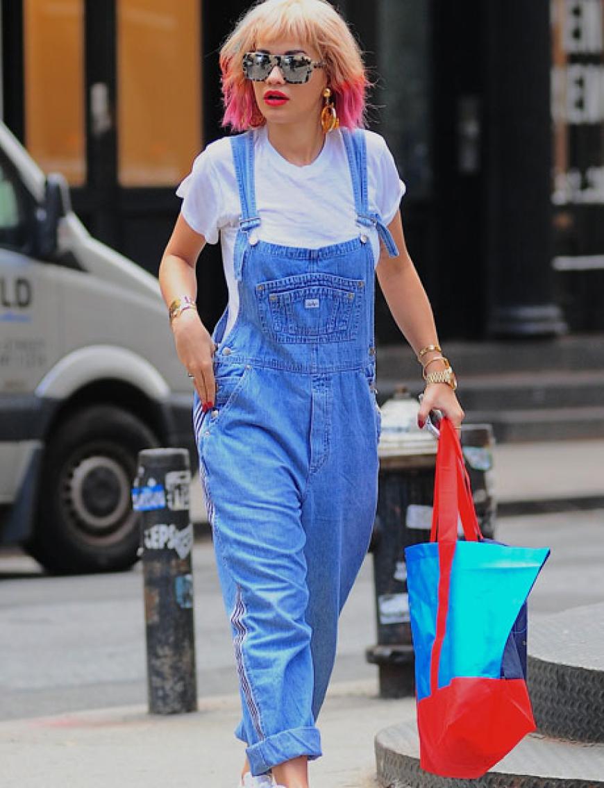 Coole Jeans-Latzhose, T-Shirt, pinkfarbene Haarspitzen und eine coole Brille. Na, erkennen Sie diesen Star? Es ist Rita Ora, die versucht