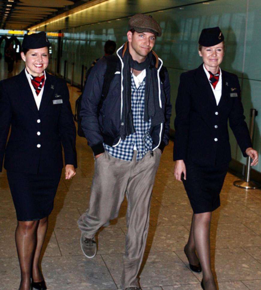Sonderservice: Womanizer Bradley Cooper wird gleich von zwei Stewardessen über den Flughafen von Heathrow eskortiert