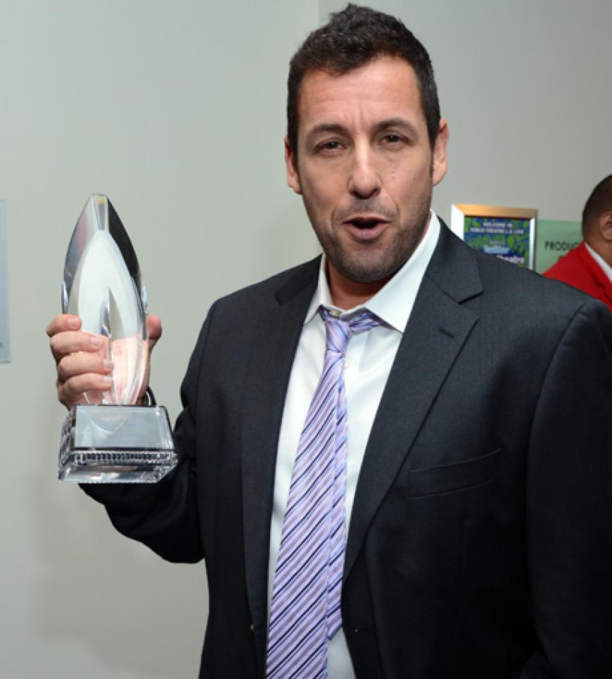 Adam Sandler hält stolz seinen Preis in die Kameras