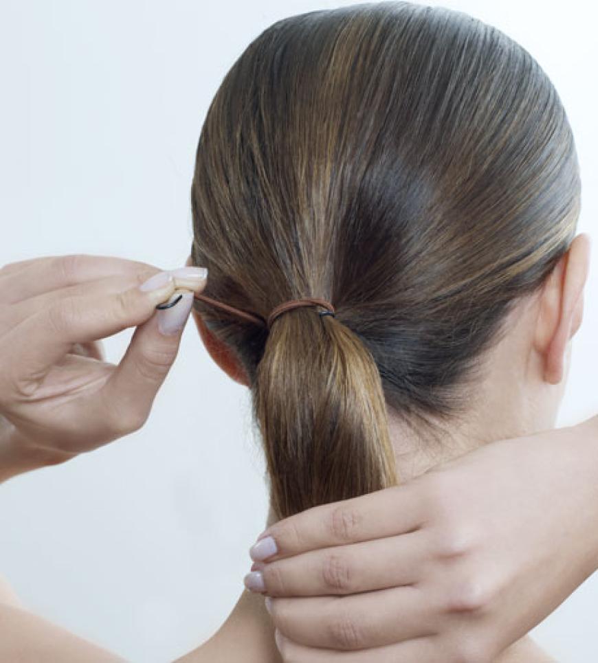Seitenscheitel am Vorderkopf ziehen und mit einer Bürste die Haare zu einem tiefsitzenden Pferdeschwanz zusammen nehmen.
