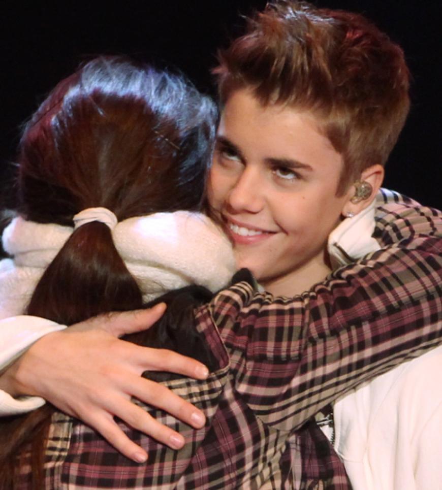 Justin Bieber umarmt einen Fan auf der Bühne