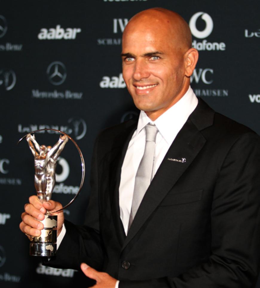 Surfer Kelly Slater hält stolz seine Trophäe in der Hand