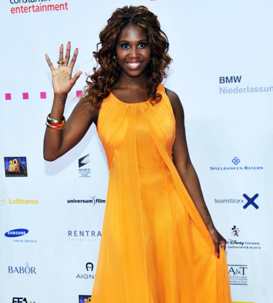 Motsi Babuse strahlt im orangenem Kleid für die Fotografen