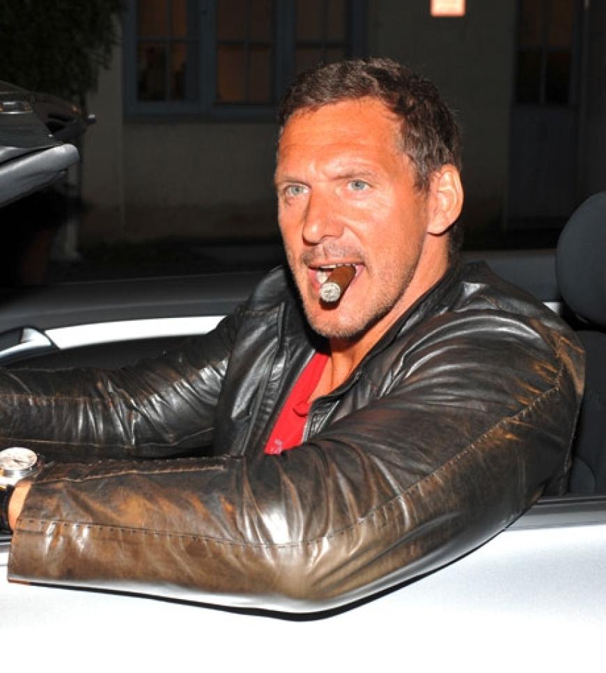 Actionheld Ralf Möller posiert mit Zigarre in einem Auto
