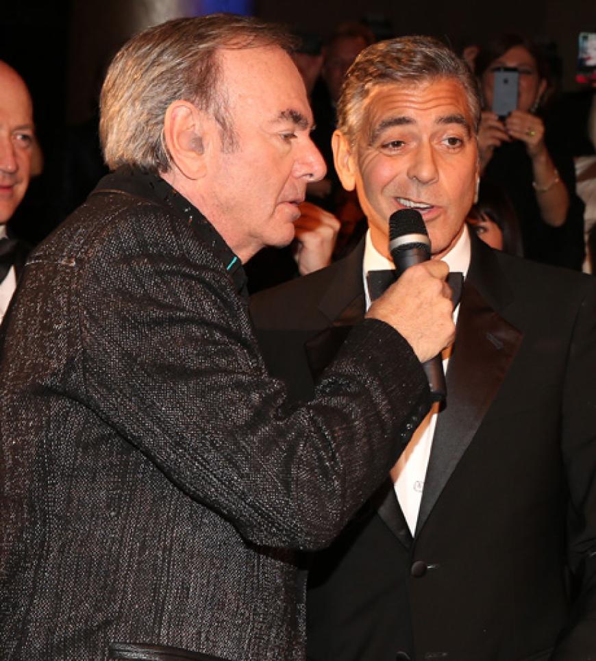 Erst kurzes Zögern bei George Clooney, der von Sänger Neil Diamond das Mikrofon an den Mund gehalten bekam ...