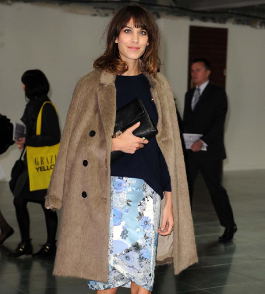 Klassiker reloaded: Ihren zeitlosen Camel-Mantel trägt die Trendsetterin lässig über den Schultern und kombiniert dazu einen auffällig bedruckten Pencilskirt