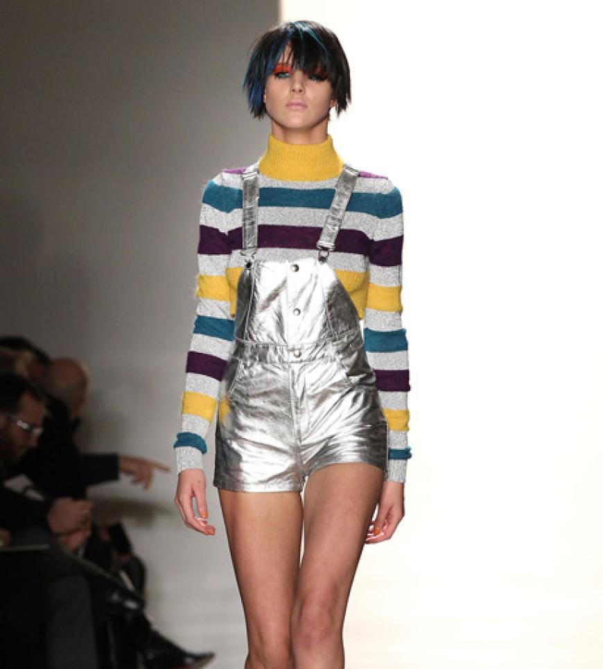 Trends im Doppelpack: Metallic trifft auf Overall! Designer Jeremy Scott kombiniert ein farbenfrohes Ringelshirt dazu.