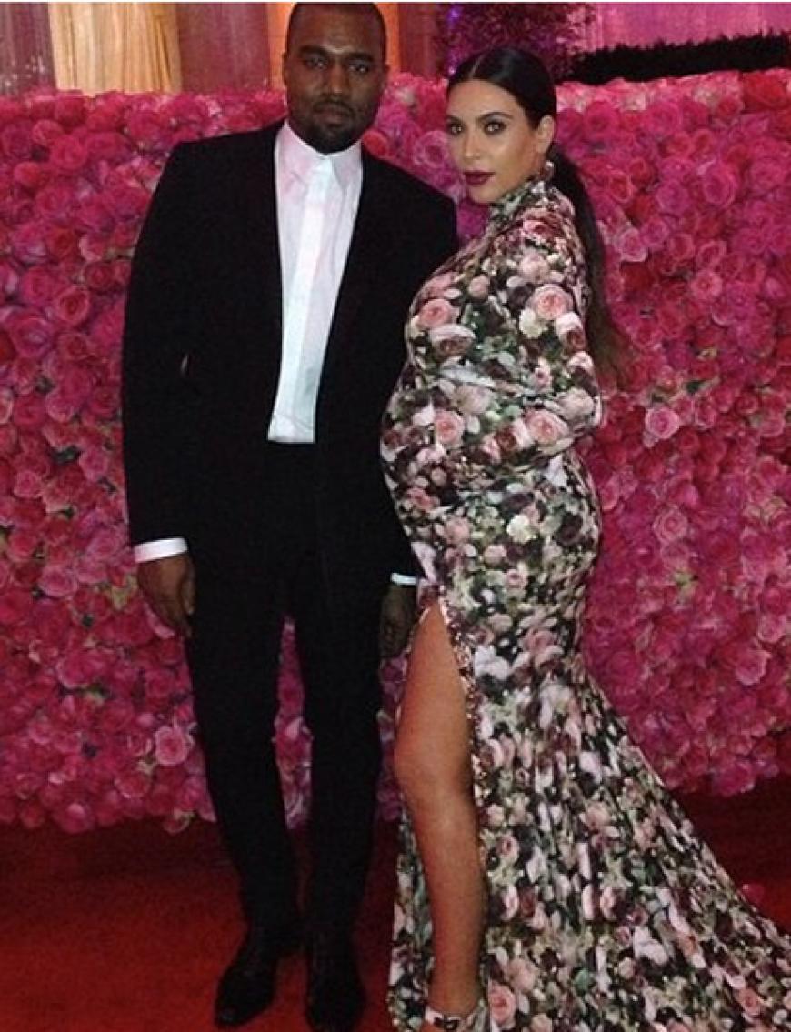 Kanye West und Kim Kardashian vor einer rosafarbenen Rosenhecke. Wie praktisch, dass Kims Kleid thematisch passte ...