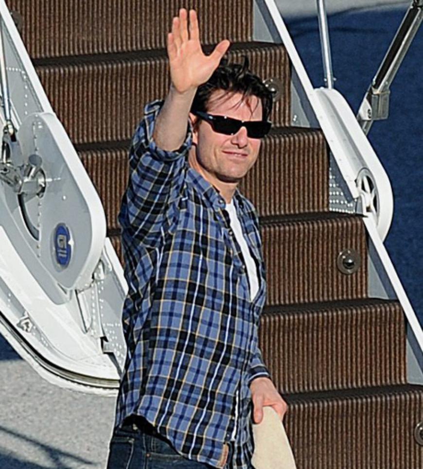 Tom Cruise winkt den Fotographen auf dem Salzburger Flughafen zu