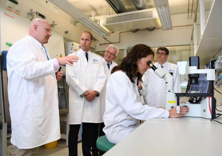 Prinz William und seine Herzogin Kate besuchen das Deutsche Krebsforschungszentrum in Heidelberg. Sie werden begleitet von Baden-Württembergs Ministerpräsident Winfried Kretschmann (Bündnis 90/Die Grünen, 3.v.l.) und Michael Baumann (r.), Vorstand Wissenschaft des dkfz.