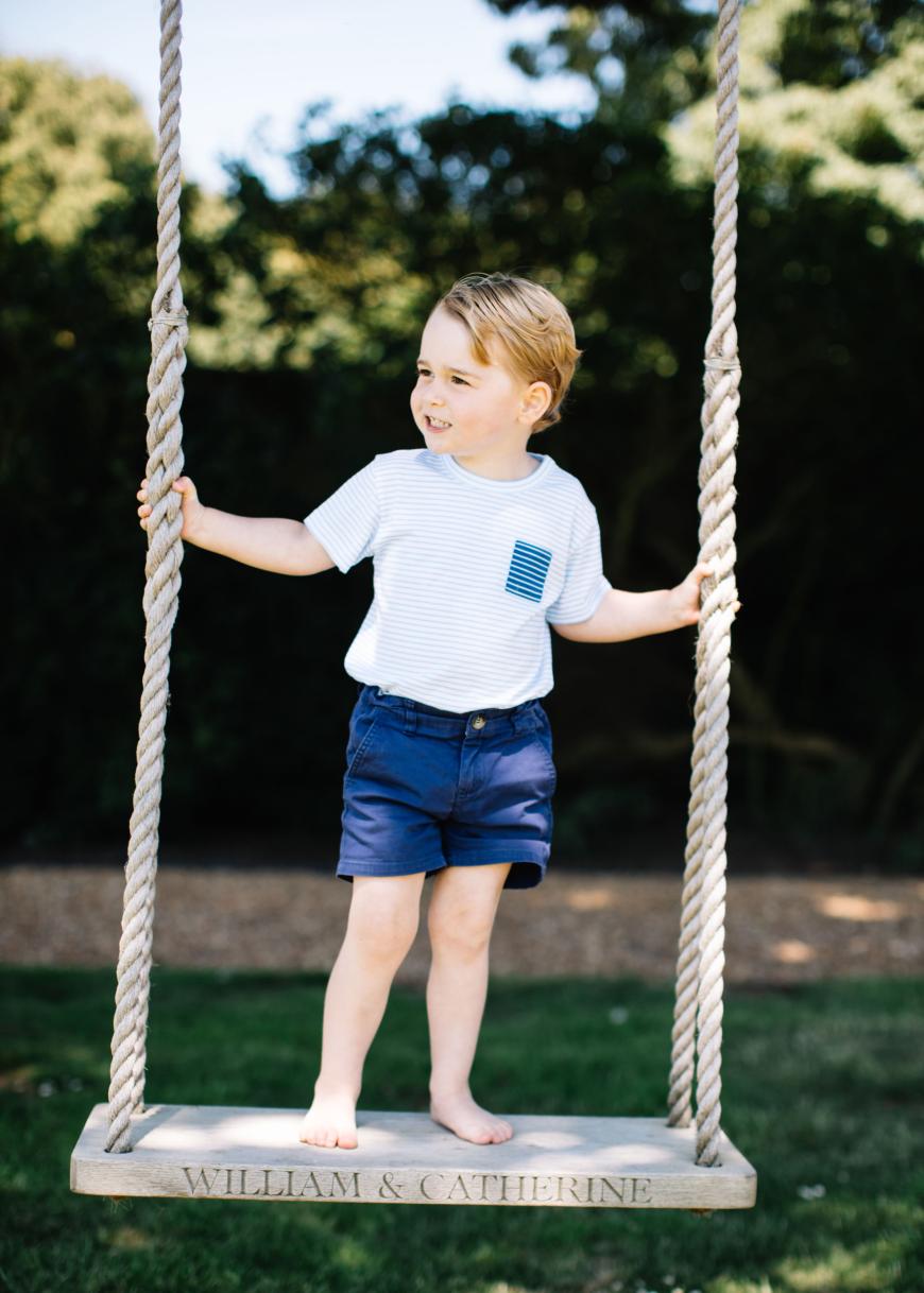 Im blau-weißen Streifen-Shirt und blauen Shorts schwingt Prinz George auf einer